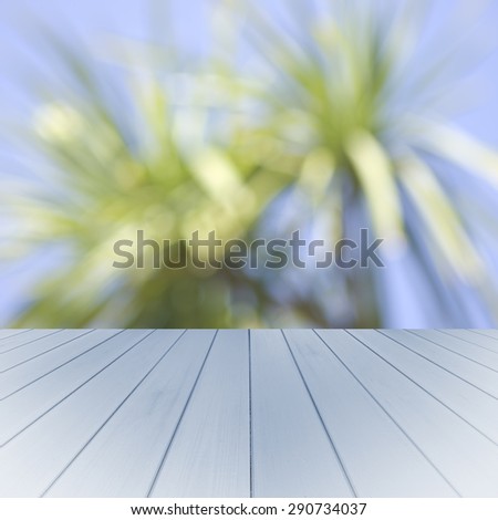 Empty wooden blue table with palms background. Ready for product display montage.