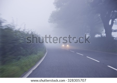Car on the road in the fog. Autumn landscape.