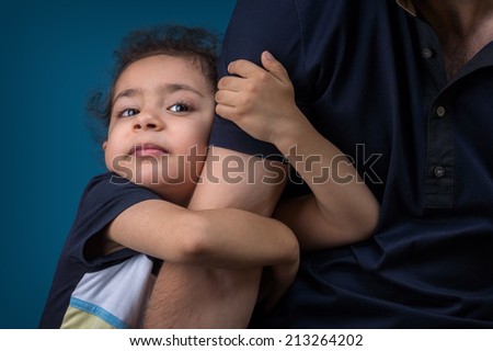 A little boy hugs his father\'s hand. Holiday \