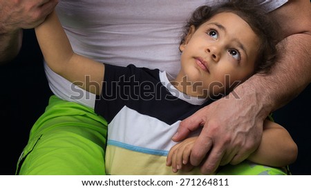 Little son communicates with his father in his arms