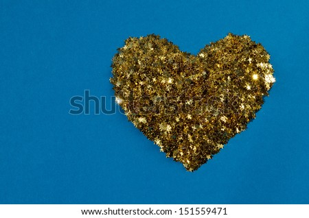 Golden Heart of stars on blue card stock Golden Christmas decoration on rough blue paper