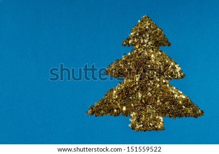 Golden tree  of stars on blue card stock Golden Christmas decoration on rough blue paper