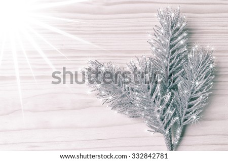 Beautiful frozen twig with sparkling stars on wooden backround and with shining Christmas light/Christmas light star/Shining Xmas decoration