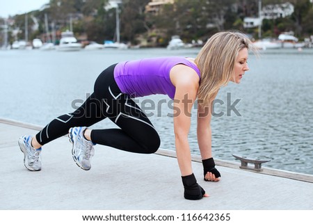 Women doing pull ups outdoors close to the water