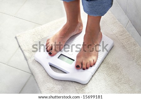 woman controlling her weight on a scale