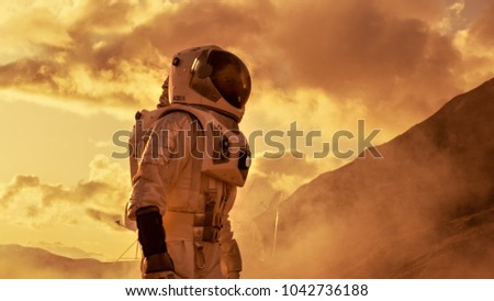Courageous Astronaut in the Space Suit Explores Red Planet Mars Covered in Mist. Adventure. Space Travel, Habitable World and Colonization Concept.