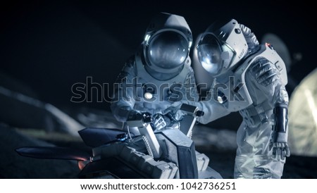 Two Astronauts in Space Suits on an Alien Planet Prepare Space Rover for Planet\'s Surface Exploration Expedition. Space Travel and Solar System Colonization Concept.