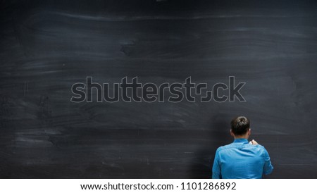 Shot of a Man Starting to Write on the Blackboard. Empty Chalkboard Perfect for Template.