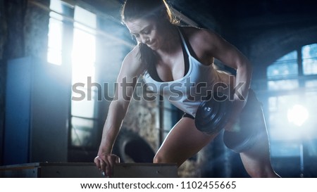 Strong Athletic Woman Does Dumbbell Bench Press Exercise as Part of Her Cross Fitness Bodybuilding Gym Exercise.