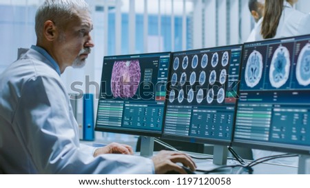 Senior Medical Research Scientist Working with Brain Scans on His Personal Computer. Modern Laboratory Working on Neurophysiology, Science,  Neuropharmacology. Understanding Human Brain.