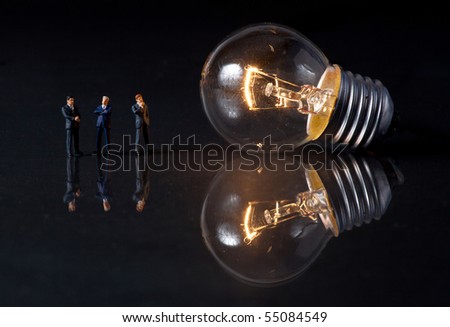 businessmen thinking, standing in front of a bulb
