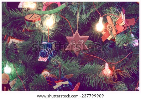 vintage filtered christmas-tree decorated with wooden toys and lights, close-up, old film