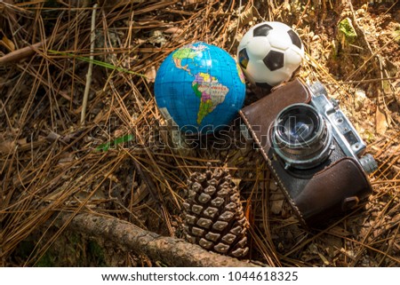 Camera on rustic floor with soccer ball and terrestrial globe