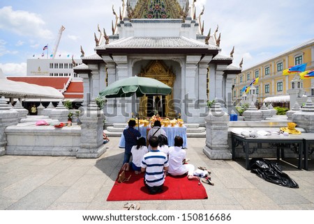 BANGKOK, THAILAND - AUGUST 17 : Unidentified Women and men offering foods to worship Bangkok city pillar shrine on August 17, 2013 in Bangkok, Thailand