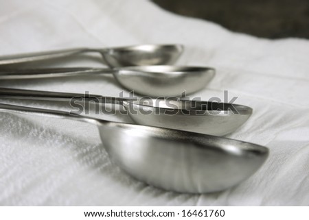 Measuring spoons laying on a white towel.