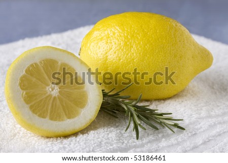 Fresh cut lemons laying on a white washcloth against a blue background.
