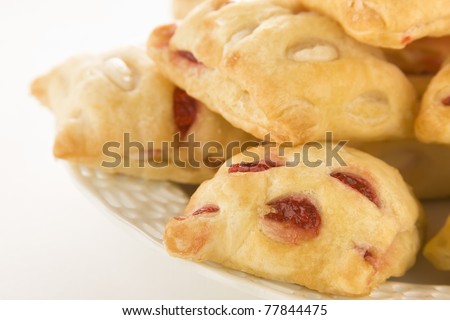 Strawberry strudel bites piled on a white dish against a white background.