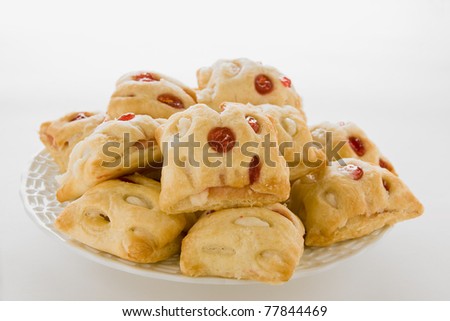 Strawberry strudel bites piled on a white dish against a white background.