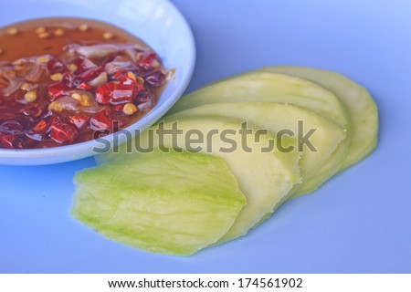 mangoes with sauce, mangoes dipped into a sweet fishy paste with dried shrimp and red onions in plate