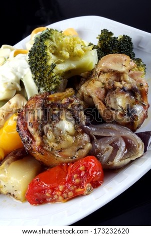 colorful steamed vegetables with chicken drumstick and colorful pasta with white sauce