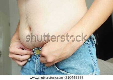 Fat man with a big belly try wearing jeans