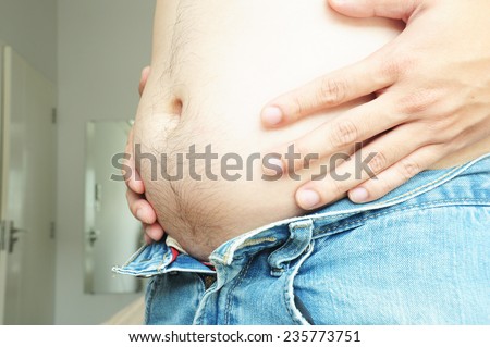 Fat man with a big belly cannot wearing jeans