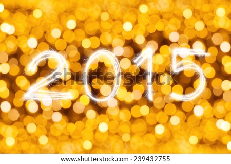 New Year 2015 writing sparkle firework figures on defocused gold light blur bokeh background