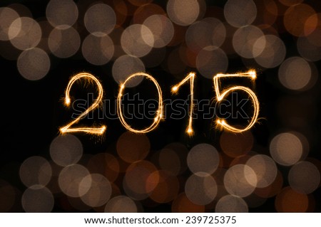 Happy New Year 2015 sparkle firework writing with dirty defocused gold lights blur bokeh background