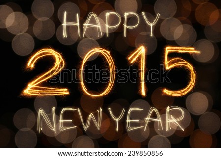 Happy New Year 2015 sparkle firework writing with unfocused dirty gold light blur bokeh background