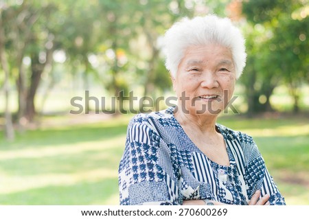 Portrait of a smiling elderly woman in public park