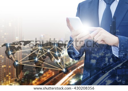 Double exposure of businessman touching with smart phone world business network connection and city center of business, Technology communication business and finance concept, world map from NASA