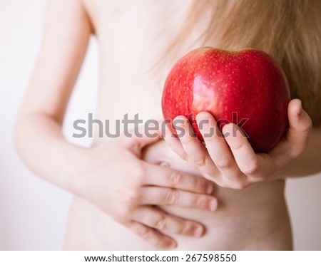 Unrecognizable little girl holding a red apple, white background