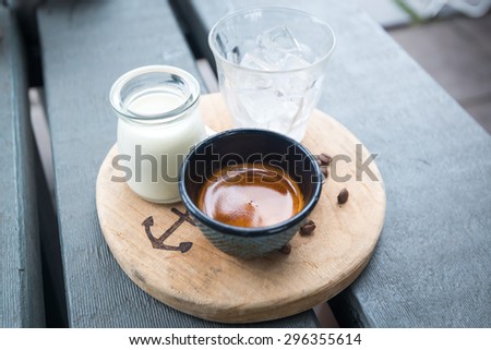 Ice Coffee with milk and ice and coffee seed on wood