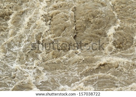 foaming stream of dirty water