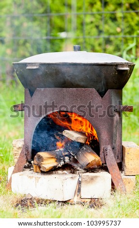 Chorba soup being made in kazan suspended above a fire using a metal frame