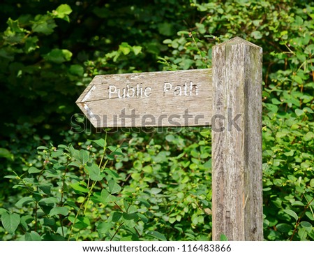 Weathered wooden sign post pointing to Public Path