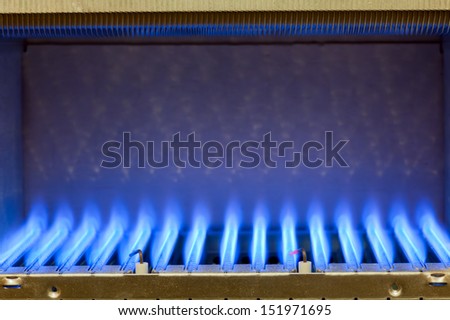 Blue flames of a gas burner inside of a boiler