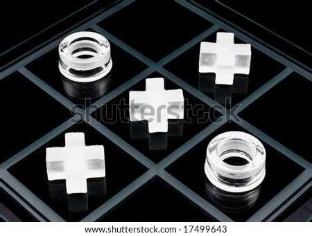 Glass tic-tac-toe game on black background