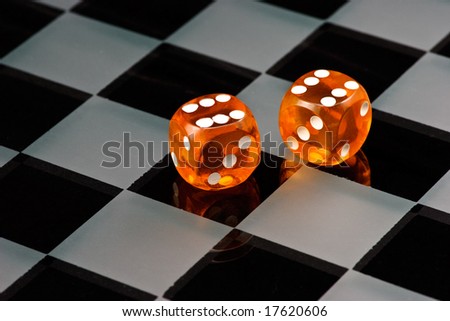 Two cube amber dice with rounded corners on checkered board