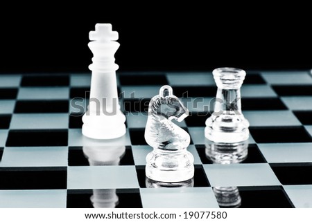 Glass chess pieces on glass board, White is in check