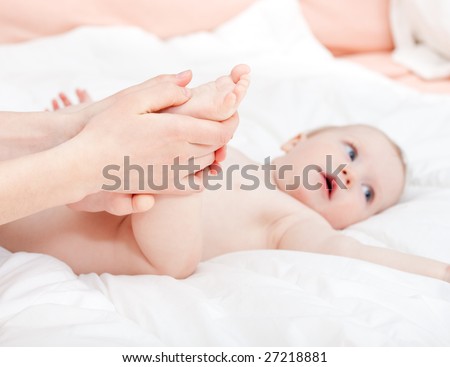 Mother massaging her child\'s foot, shallow focus