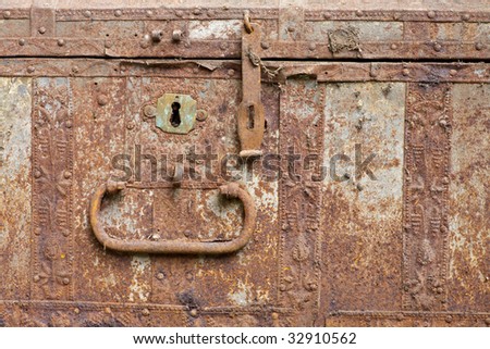 Front of old rusty chest with keyhole and bolt
