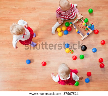 Top view of three little girls playing on the floor