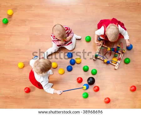 Top view of three little girls playing on the floor