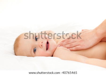 Mother massaging her little baby girl, shallow focus