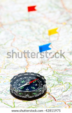 Compass on map with color flag pins