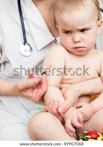 Doctor giving a child an intramuscular injection in arm, shallow DOF