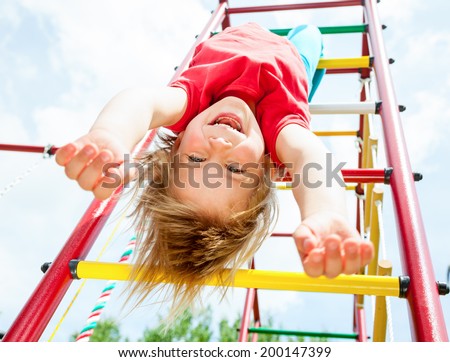 Little girl having fun playing on monkey bars