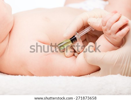 Close-up shot of pediatrician giving a three month baby girl  intramuscular injection in arm
