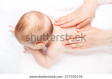 Three month baby girl is receiving back massage from a female massage therapist